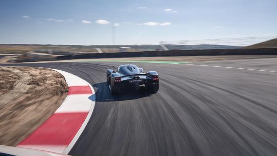 Aston Martin Valkyrie rijdend over circuit zwart zijkant achter door bocht