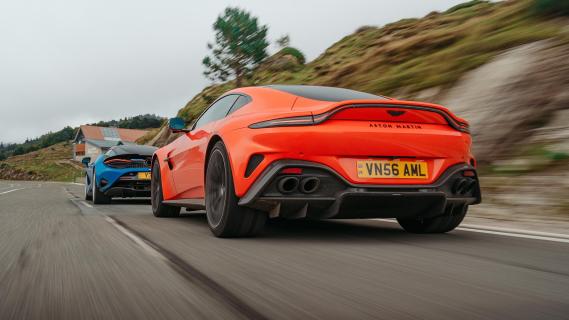 McLaren 750S blauw Aston Martin V8 Vantage oranje zijkant achter rijdend op weg