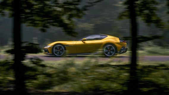 Ferrari 12Cilindri geel zijkant links bomen weg