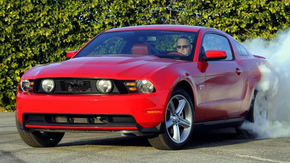 Ford Mustang GT facelift rood (2010) zijkant voor schuin links burnout