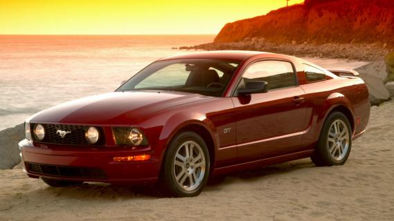 Ford Mustang GT (2005) rood zijkant rechts voor schuin strand ondergaande zon