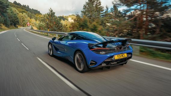 McLaren 750S blauw zijkant achter schuin rijdend weg