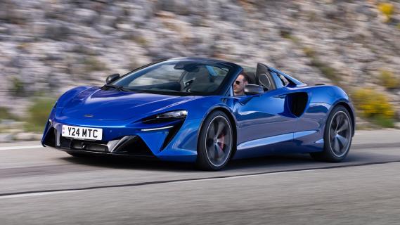 McLaren Artura Spider (2024) blauw zijkant voor schuin links dak open rijdend op weg