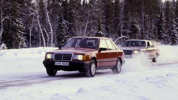 Mercedes 200d rood zijkant met voorganger W124 en W123 in de sneeuw