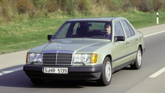 Mercedes W124 zijkant groen zijkant voor weg rijdend