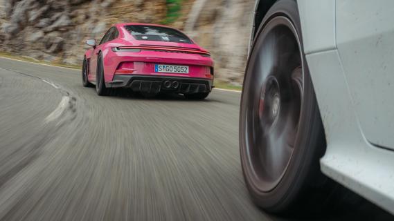 Porsche 911 S/T roze zijkant achter schuijn in bocht rijdend Toyota GR Yaris wit voorwiel