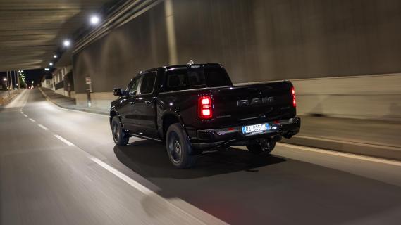 Ram 1500 Laramie (2025) zwart links achter schuin rijdend donker verlichting aan