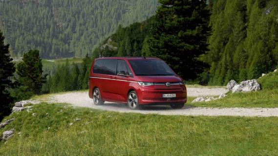 Volkswagen Multivan eHybrid 4Motion (2024) rood zijkant voor rijdend door de bergen