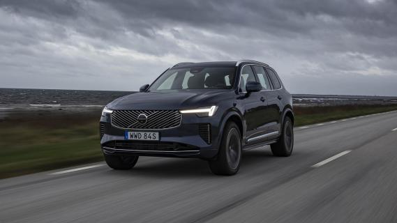 Volvo XC90 T8 blauw (2025) zijkant links voor rijdend grijze lucht