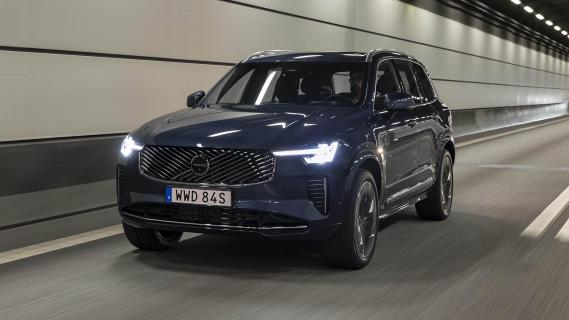 Volvo XC90 T8 blauw (2025) zijkant links voor rijdend door tunnel koplampen aan