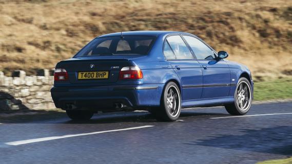 BMW M5 (E39) blauw (2001) zijkant rechts achter schuin rijdend door bocht