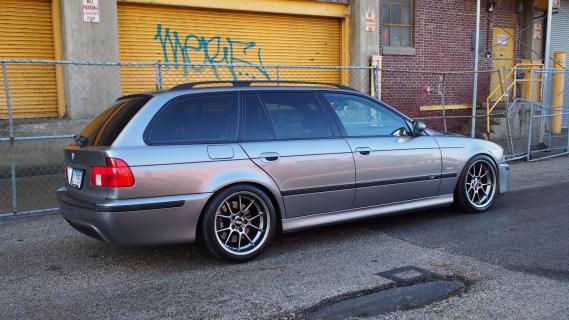 BMW M5 Touring (E39) grijs (2003) zijkant rechts schuin achter schuur