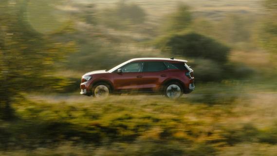 Ford Explorer rood (2025) zijkant rijdend