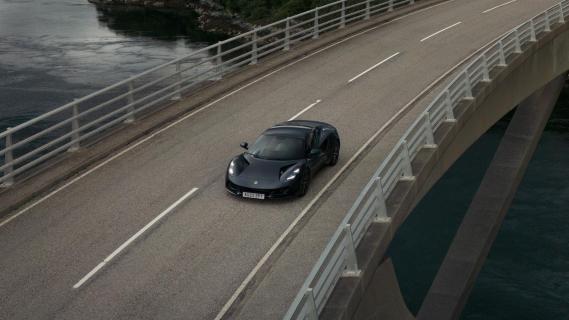 Lotus Emira i4 grijs (2025) zijkant links schuin voor hoog op brug