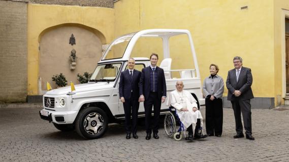 Mercedes G580 (W465) wit (2024) elektrisch zijkant linksvoor schuin gele muur buiten met de paus ervoor