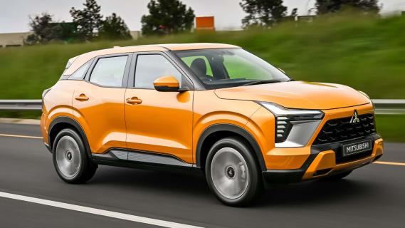 Mitsubishi Outlander Sport oranje (2025) zijkant rechts schuin rijdend op weg