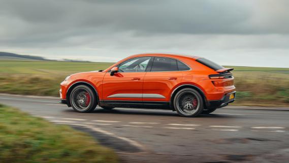 Porsche Macan Turbo Electric oranje (2025) zijkant links rijdend