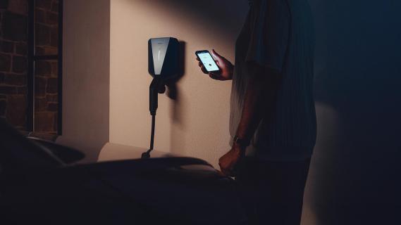 Easee Charge Max advertorial 2025: lader aan muur, telefoon in hand