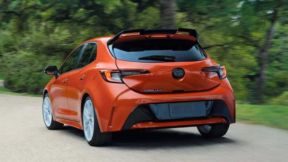 Toyota Corolla FX Edition oranje (2025) zijkant links achter schuin rijdend