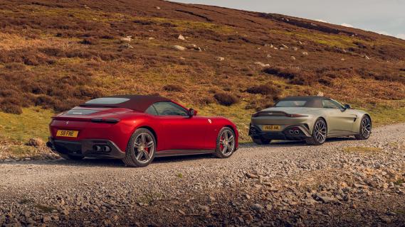 Aston Martin Vantage Roadster grijs & Ferrari Roma Spider rood zijkant achter rechts schuin
