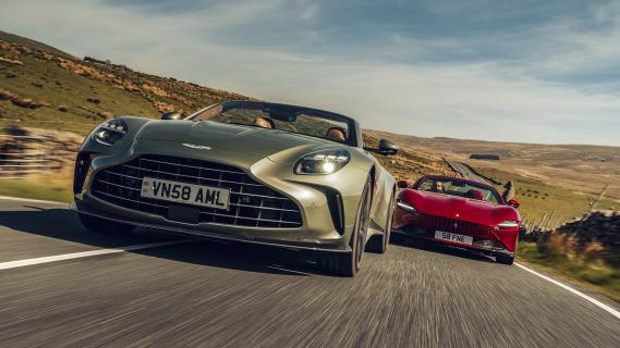 Aston Martin Vantage Roadster grijs & Ferrari Roma Spider rood zijkant voor rijdend