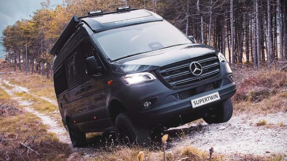 Adria Supertwin 4x4 (2024) links schuin voor op verhoging keien klimmend