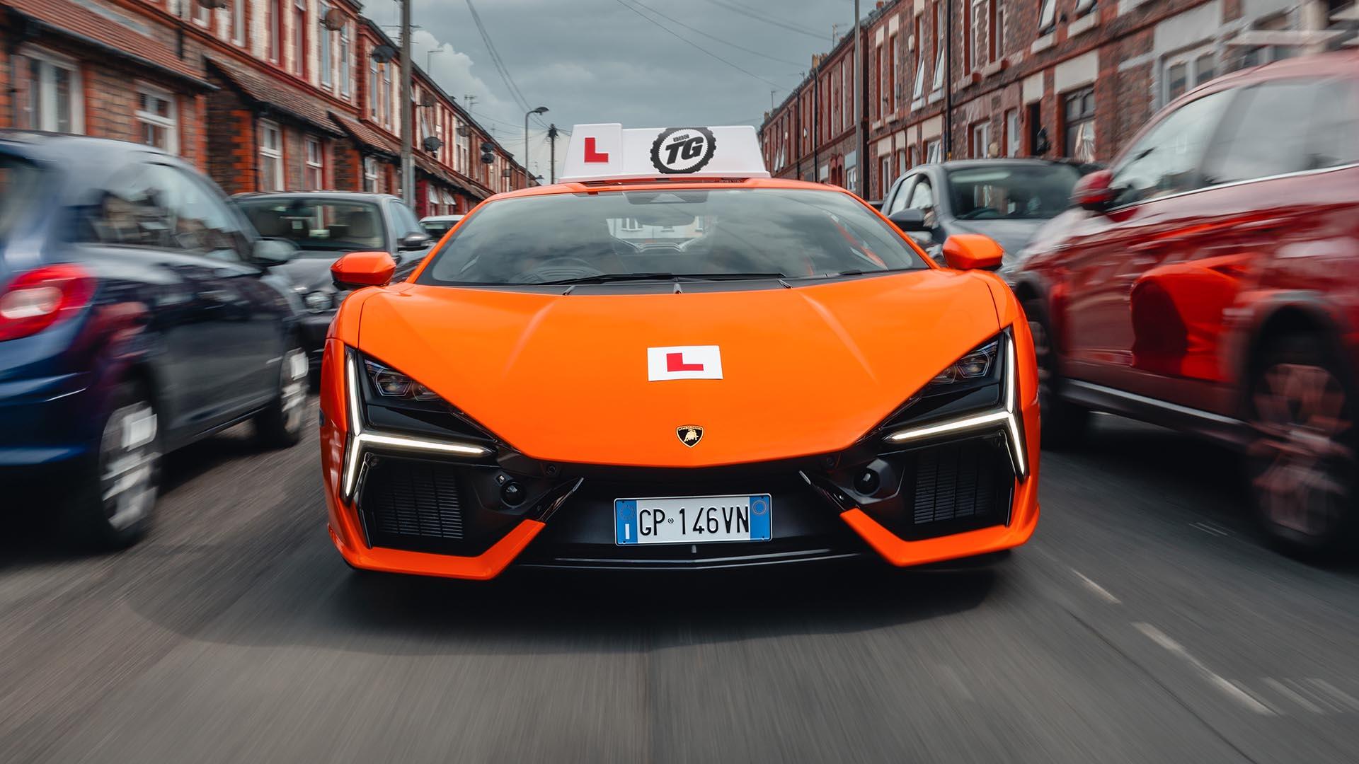 Lamborghini Revuelto lesauto oranje zijkant recht van voren rijdend