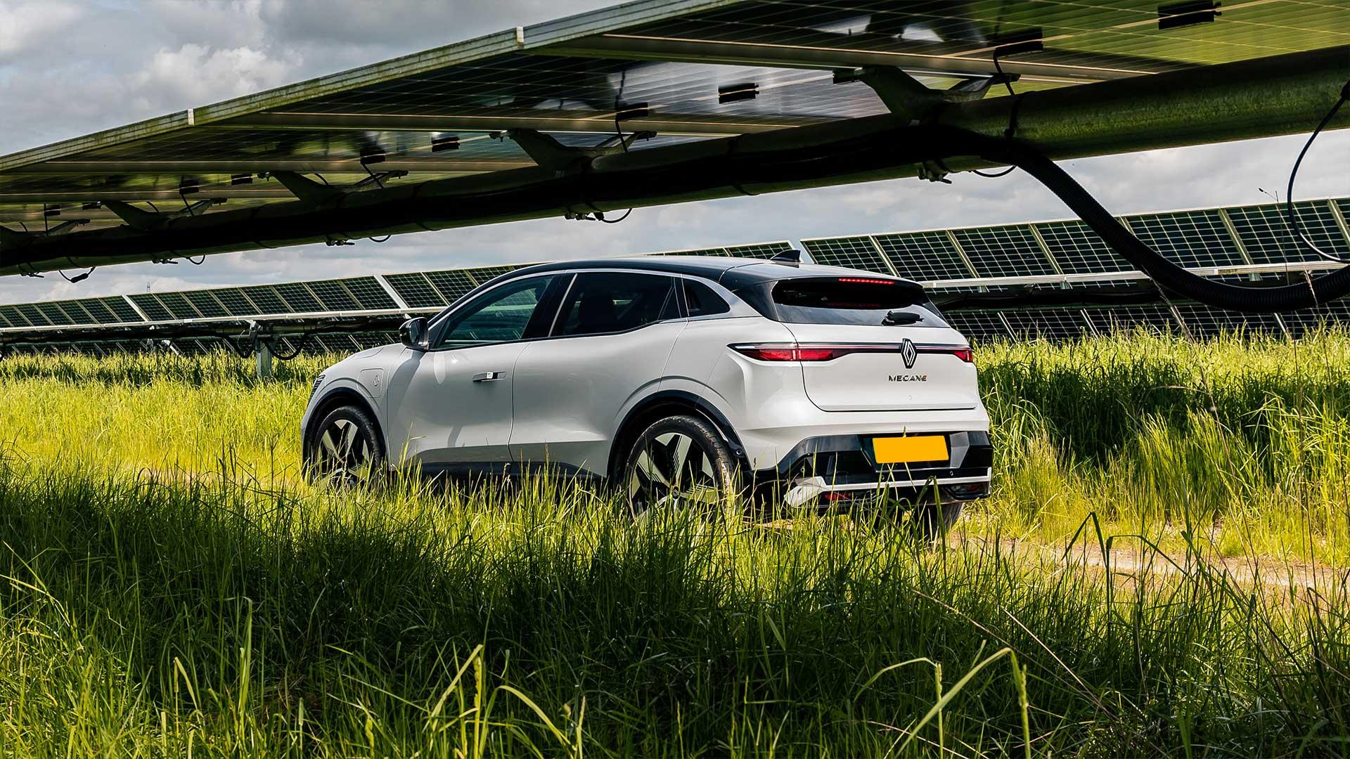 Renault Megane bij zonne-panelen in een grasveld