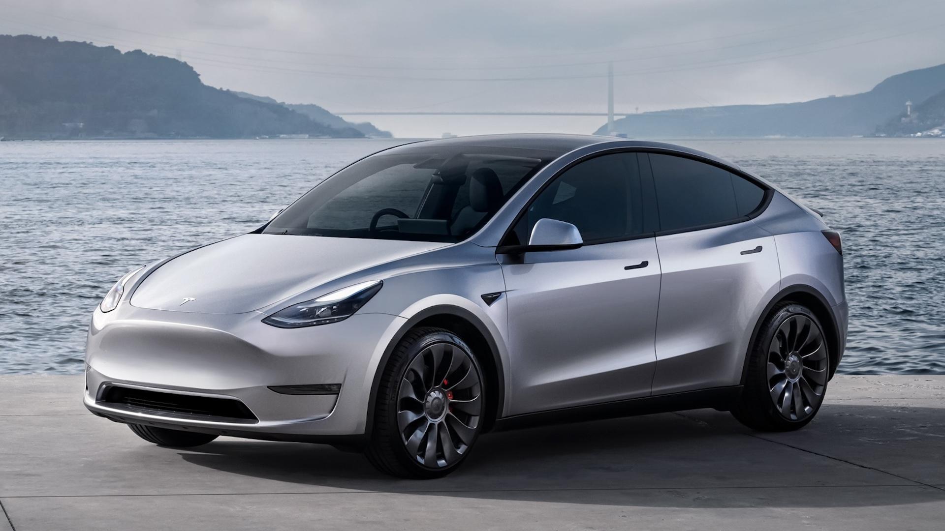 Tesla Model Y grijs voor zijkant schuin water