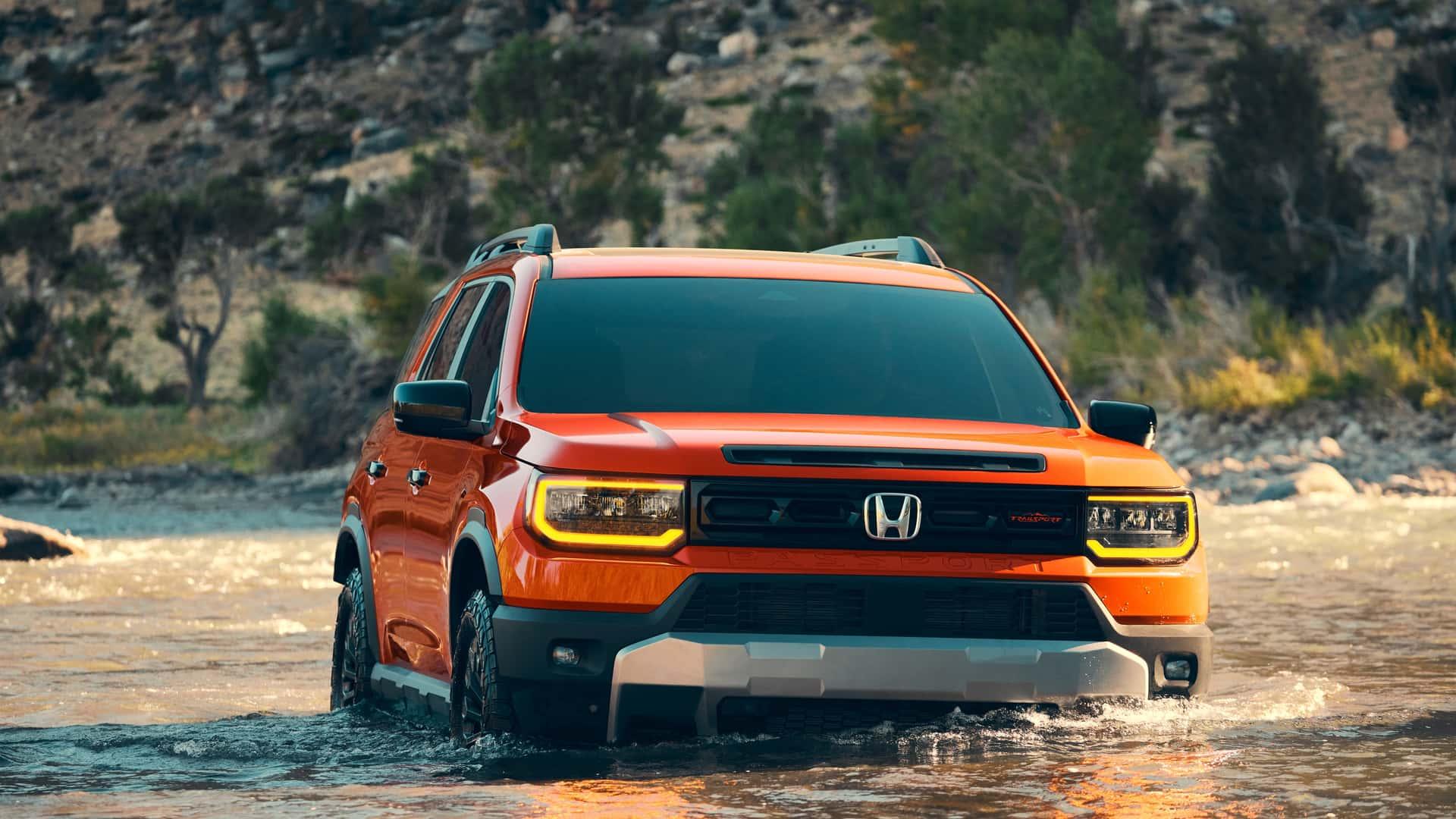 Honda Passport oranje (2026) zijkant voor schuin rechts door water