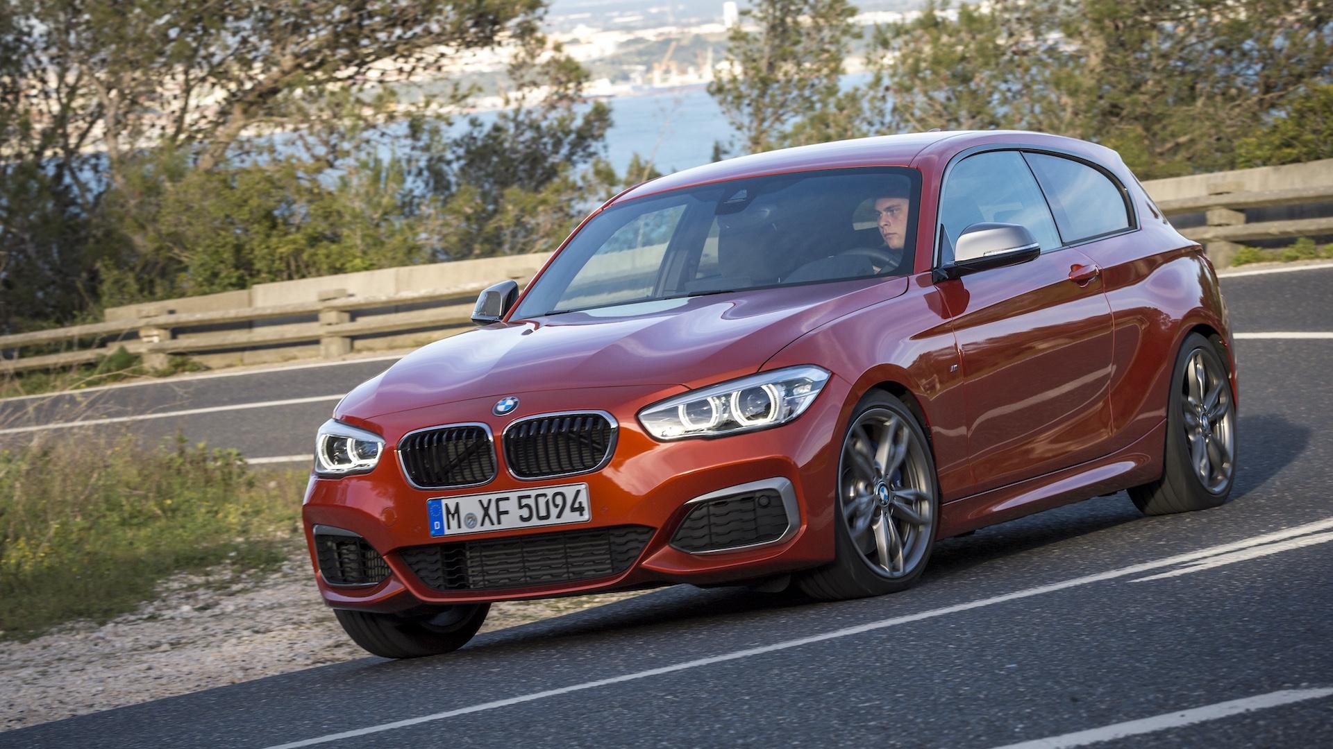 BMW M135i (F21, LCI) oranje (2015) zijkant schuin door bocht