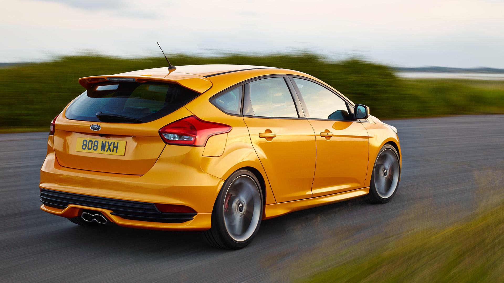 Ford Focus ST (DYB) oranje (2025) zijkant rechts schuin achter rijdend