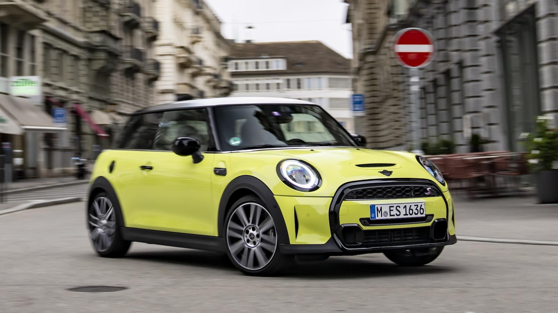 Mini Cooper S (F56, LCI2) geel (2021) zijkant rechts voor schuin rijdend door bocht in stad