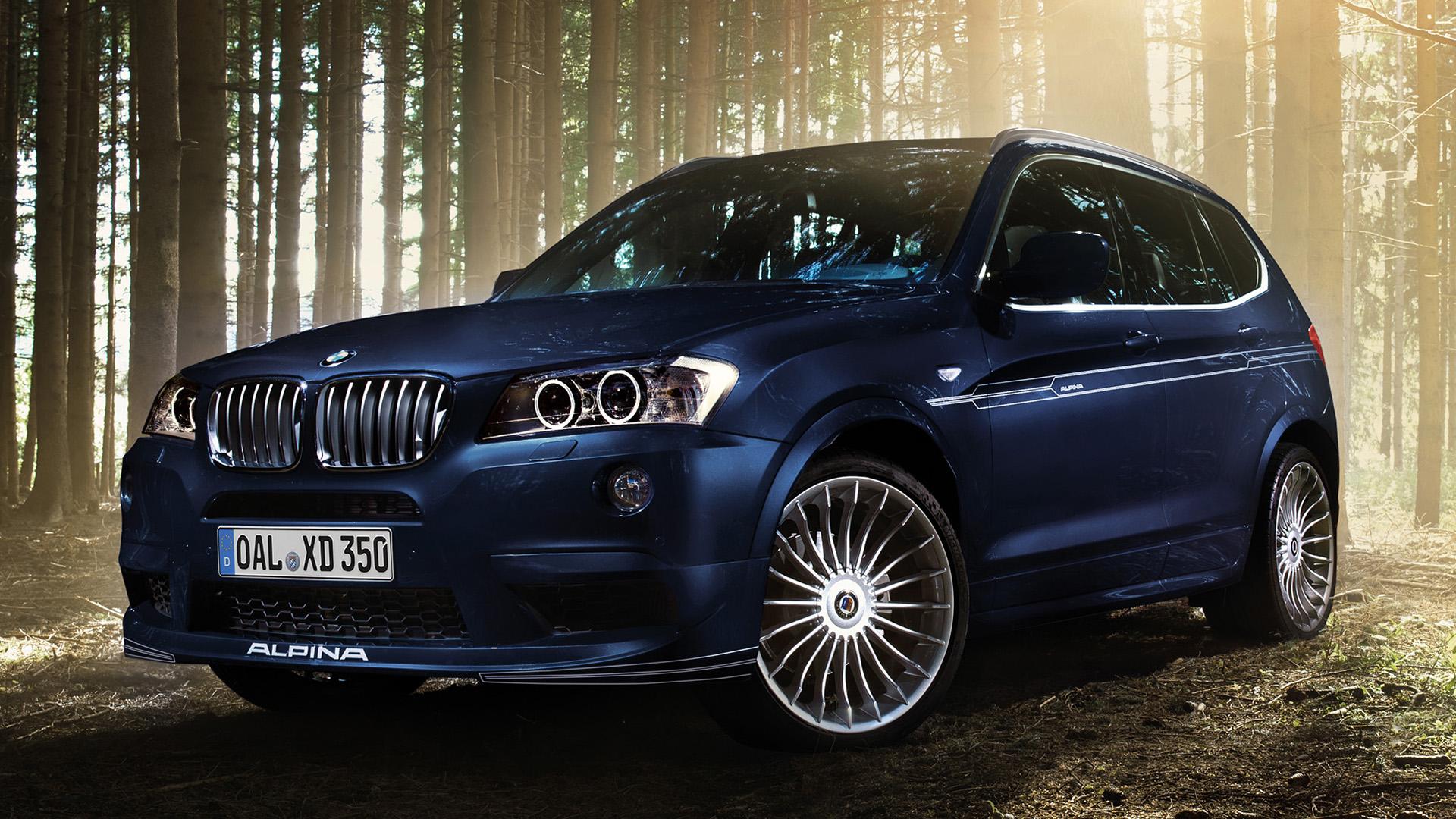 Alpina XD3 Bi-Turbo (F25) blauw zijkant links schuin in bos bomen zonlicht