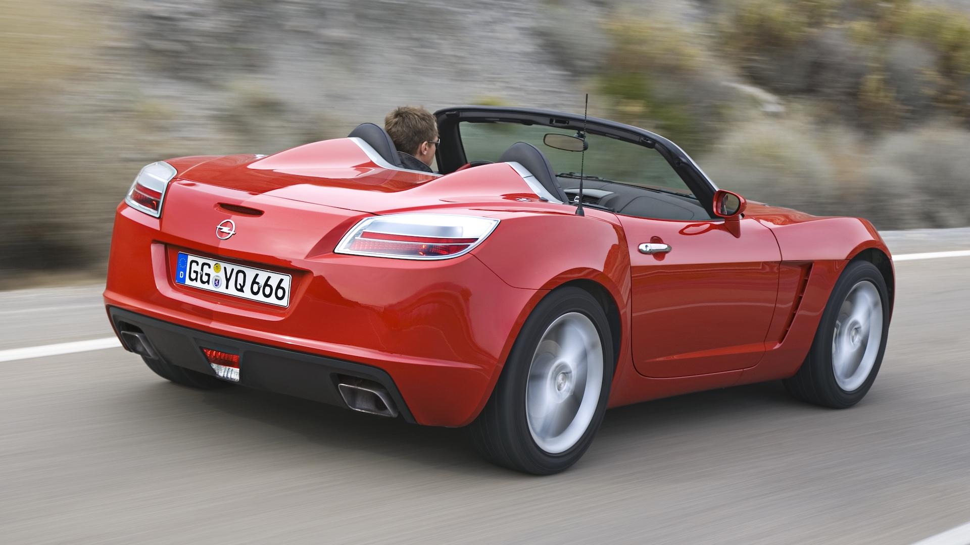 Opel GT rood (2007) zijkant schuin rechts achter rijdend op weg dak omlaag