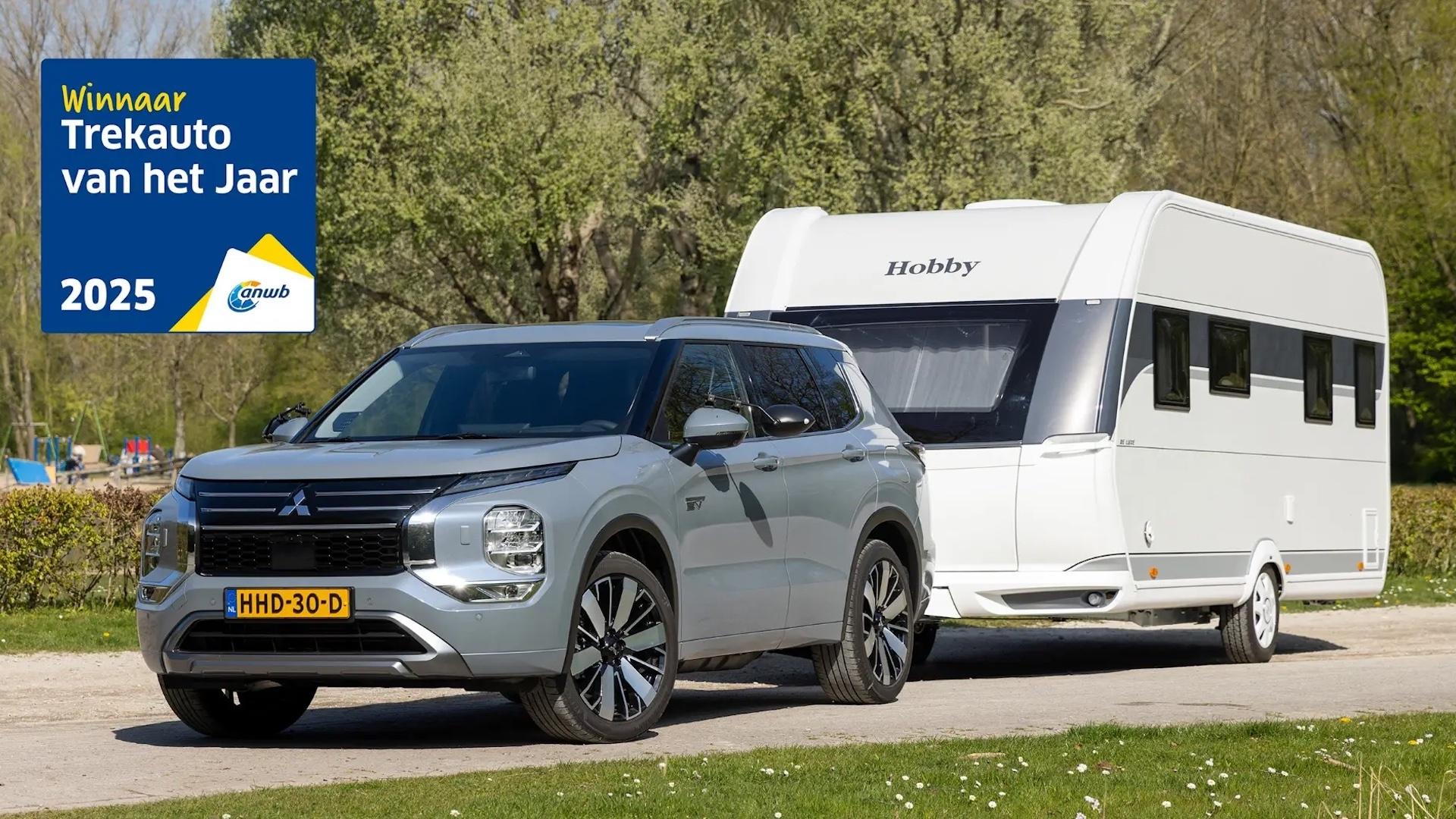 Mitsubishi Outlander PHEV grijs (2025) zijkant links schuin voor met een caravan van Hobby erachter