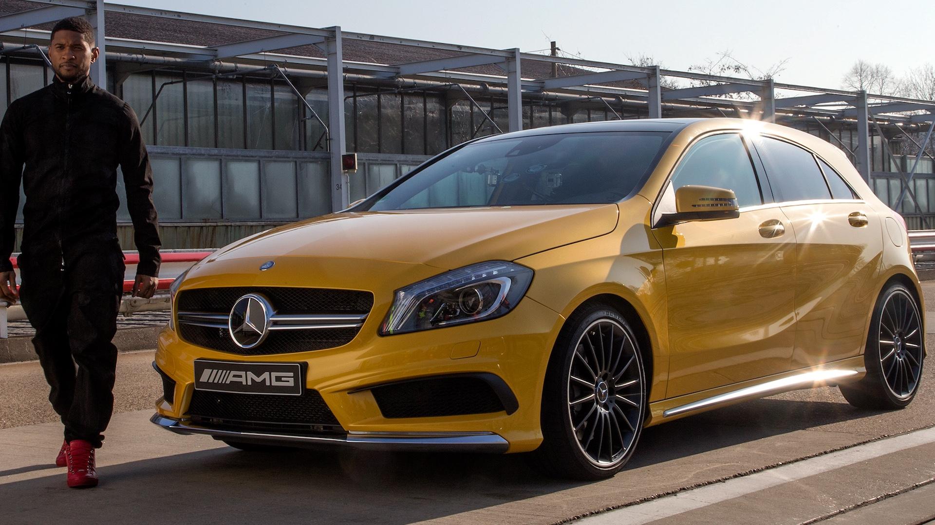 Mercedes A45 AMG (W176) geel (2013) zijkant links voor schuin en iemand die lijkt op Usher pitlane