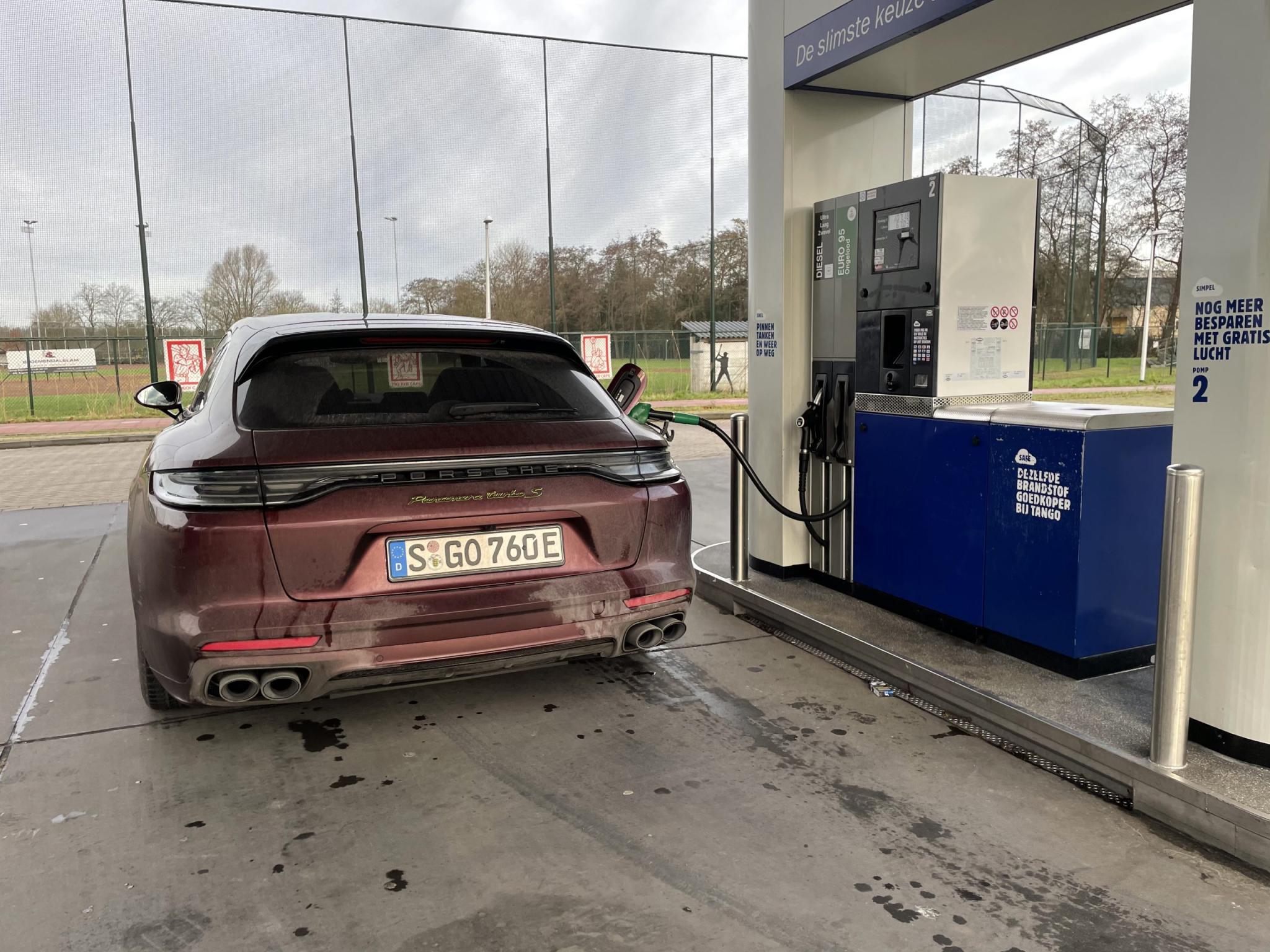 Porsche Panamera Sport Turismo Turbo S E-Hybrid tanken bij het tankstation. Benzine, geen diesel. Vies, wassen, pekel, modder