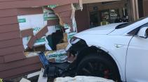 witte auto botst tegen gebouw