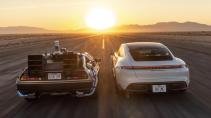 Porsche Taycan en de DeLorean DMC-12 uit Back to the Future richting de zonsondergang