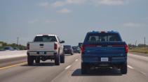 Ford F-150 Lightning rijdend op een snelweg naast een Chevrolet Silverado