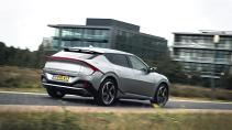 Kia EV6 GT rijdend op een weg schuin achter