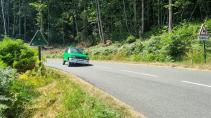 Renault 5 elektrisch rijdend op een weg overhellend