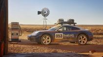 Porsche 911 Dakar 992 Roughroads kleurstelling zijkant bij oud benzinepomp saharazand