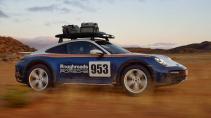 Porsche 911 Dakar Roughroads kleurstelling rijdend op een zandweg zijkant stof