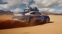 Porsche 911 Dakar Roughroads kleurstelling rijdend op een zandweg schuin achter