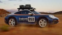 Porsche 911 Dakar Roughroads kleurstelling rijdend op een zandweg schuin voor