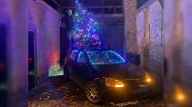 Volkswagen Golf met kerstboom op het dak schuin voor