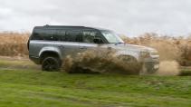 Land Rover Defender 130 rijdend door plas water zijkant