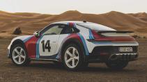 Porsche 911 Dakar met Martini-kleurstelling in de woestijn schuin achter